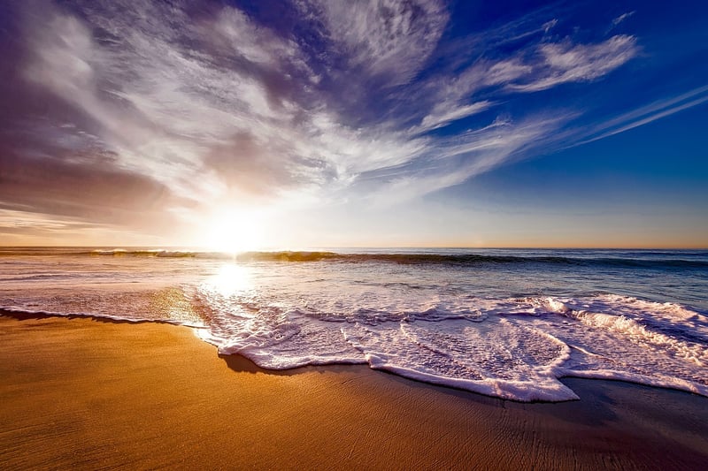 Woman walking on the beach at sunset